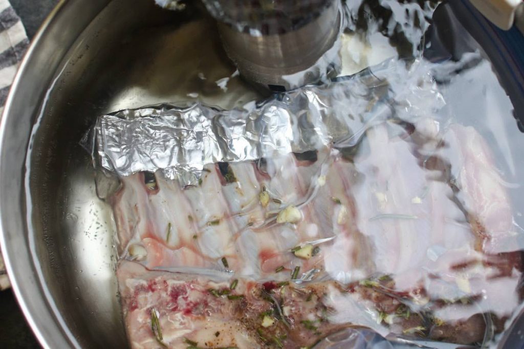 Sous vide cooking the rack of lamb in a warm water bath.