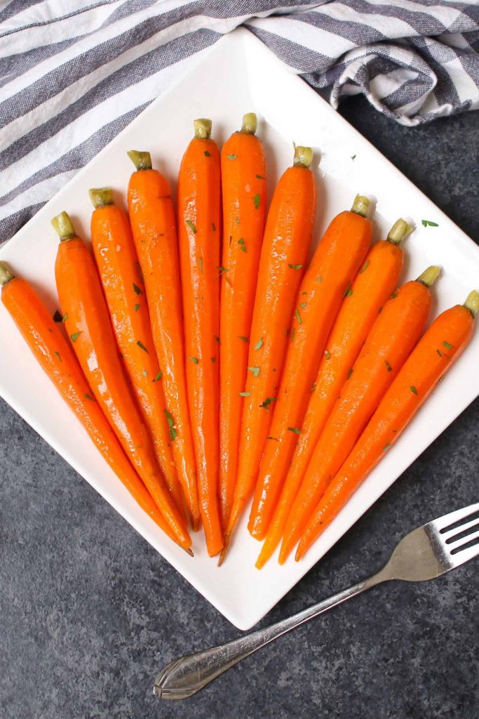 Estas zanahorias glaseadas con miel al vacío son zanahorias tiernas y sabrosas cocidas a fuego lento en una mezcla de miel y mantequilla, luego cubiertas con una pizca de perejil. El método al vacío transforma las zanahorias en trozos perfectamente tiernos. Dulce, salada y llena de sabor, esta receta es una guarnición increíble para una cena festiva o una comida entre semana. #SousVideZanahorias