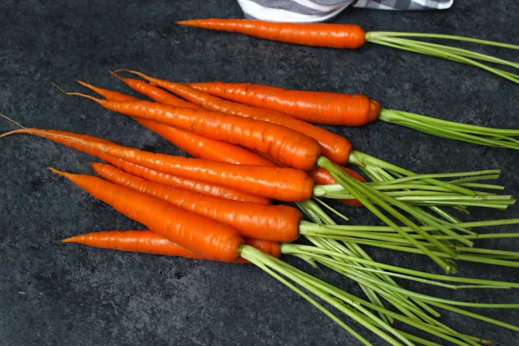 Raw fresh carrots with bright orange colour and smooth skin.