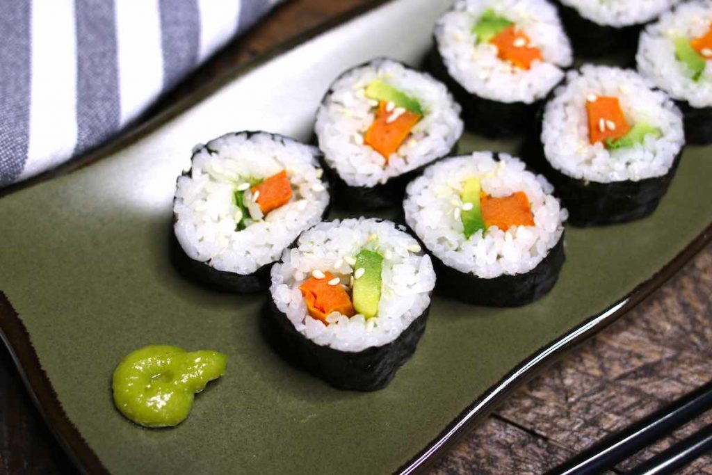 Sweet Potato Sushi Rolls served on a dark green plate with wasabi.