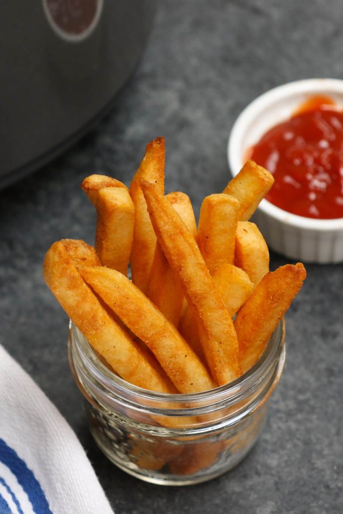 Air Fryer Frozen French Fries served with ketchup.