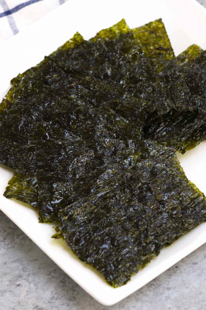 Small pieces of nori snacks on a white plate.