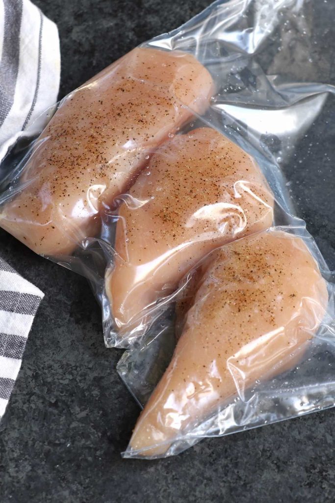 Pechugas de pollo sazonadas selladas al vacío en una bolsa zip-top.