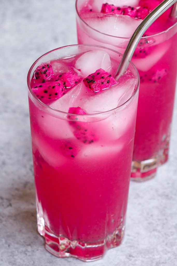 The beautiful pink Mango Dragonfruit Lemonade is a perfect summer refreshing drink that you can enjoy year-round. This easy Starbucks copycat recipe takes less than 5 minutes to make with only 4 ingredients. The dragon fruit powder gives this refresher a vibrant pink color, while the lemonade adds extra tropical fruity flavors to the iced beverage! #MangoDragonfruitLemonadeRefresher #StarbucksMangoDragonLemonade #StarbucksPinkLemonade