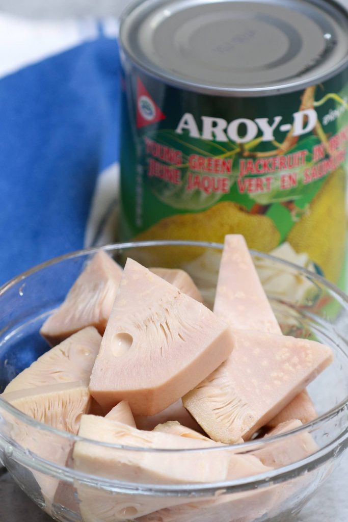 Closeup of canned young green jackfruit in a clear bowl.