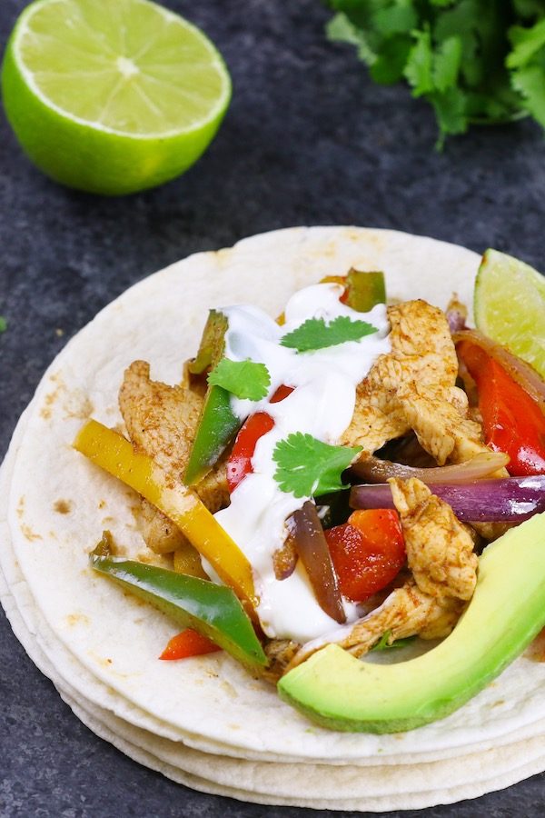 Slow Cooker Chicken Fajitas – Tender and juicy chicken breasts are cooked in the crock pot with bell peppers and onions with flavorful fajita seasonings. It takes 10 minutes to prepare in the morning and you will come home with dinner ready!#ChickenFajitas #SlowCookerChicken