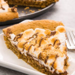 S’mores Pie / S’more Pizza is gooey, chocolatey, rich and crunchy making a perfect crowd-pleaser. It’s such an easy recipe that takes less than 30 minutes. Who needs a campfire? The combination of graham cracker crust, toasted marshmallow and rich chocolate come together, in the form of a delicious pie. So good! Quick and easy recipe. | Tipbuzz.com #smoresPie #smoresPizza