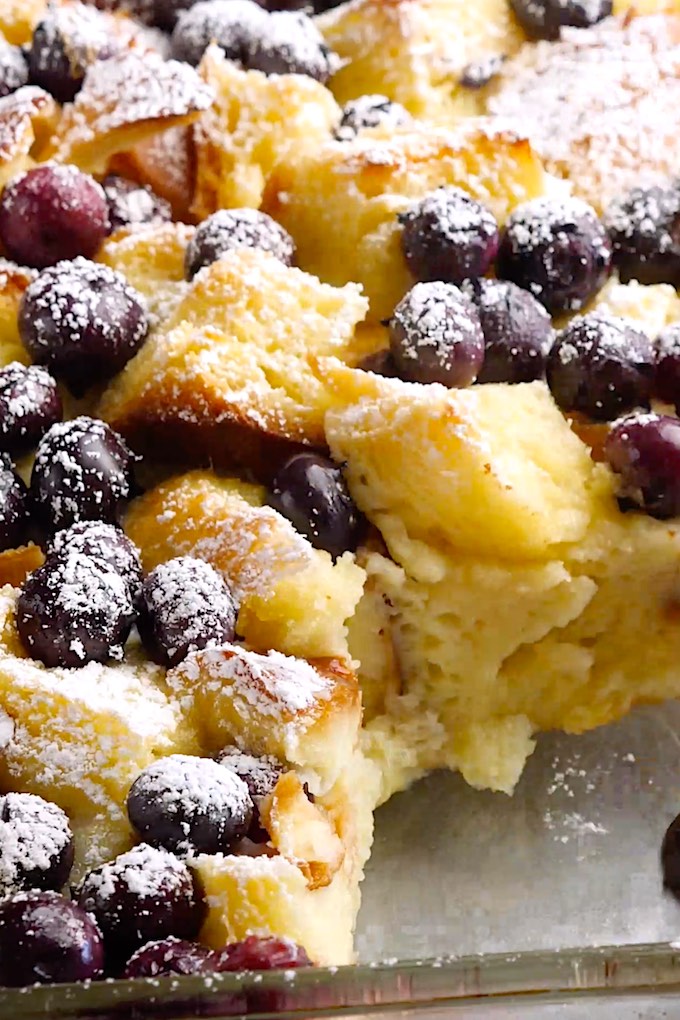 Blueberry french toast bake in a baking dish, dusted with powdered sugar!