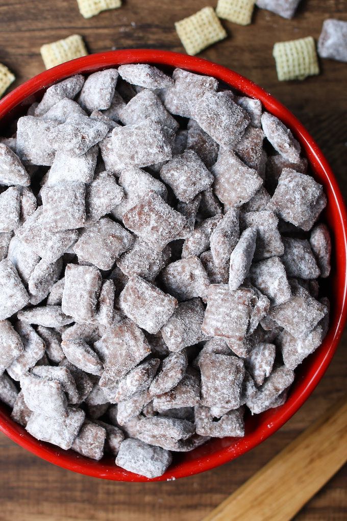 Puppy chow in a red bowl on a wooden table