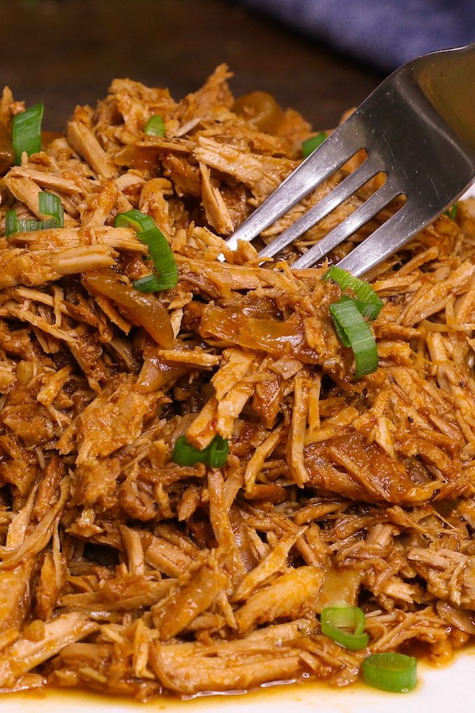 Shredded crock pot pork shoulder served on a white plate