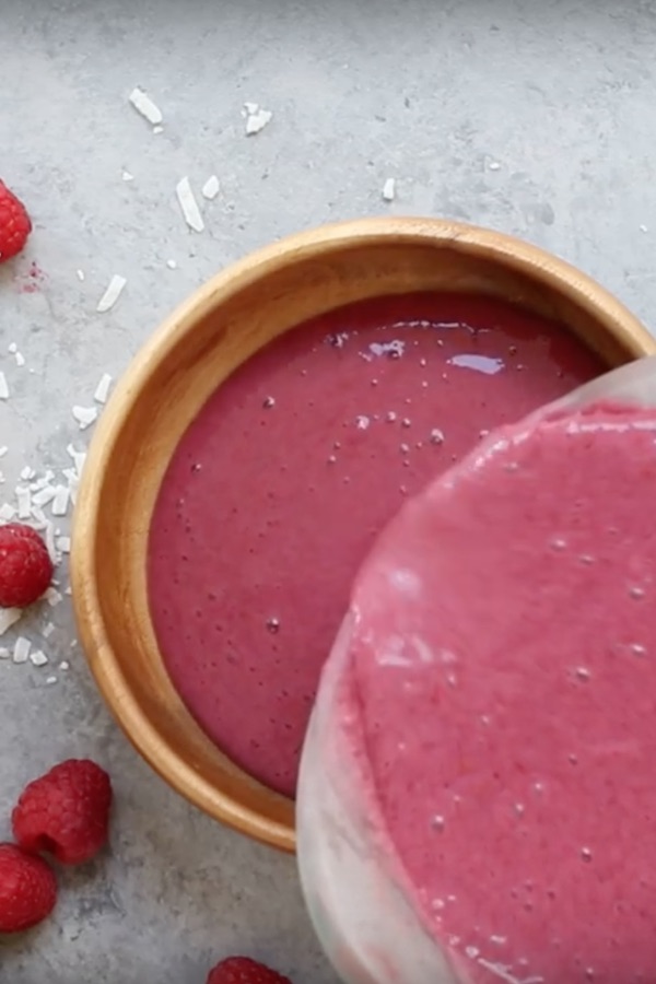 Closeup of pouring berry smoothie to show the thick and creamy texture.