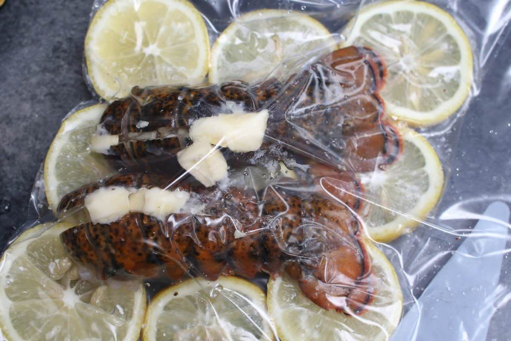 Seasoned lobster tails vacuum-sealed in a zip-lock bag.