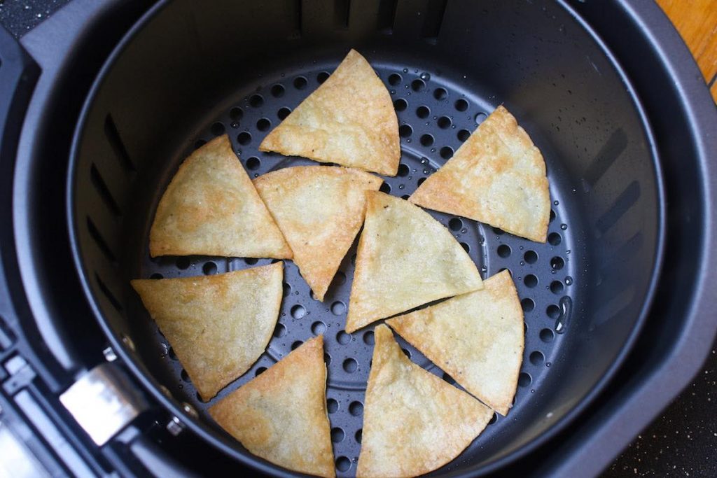 Freshly air fried tortilla chips in the basket.