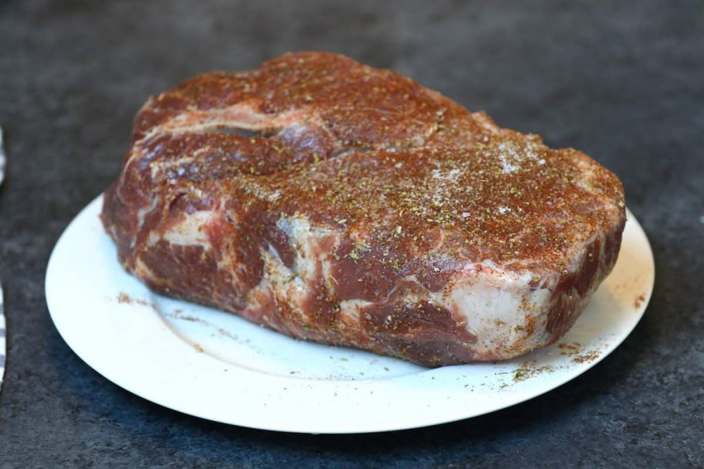 Pork shoulder seasoned with dry rub.