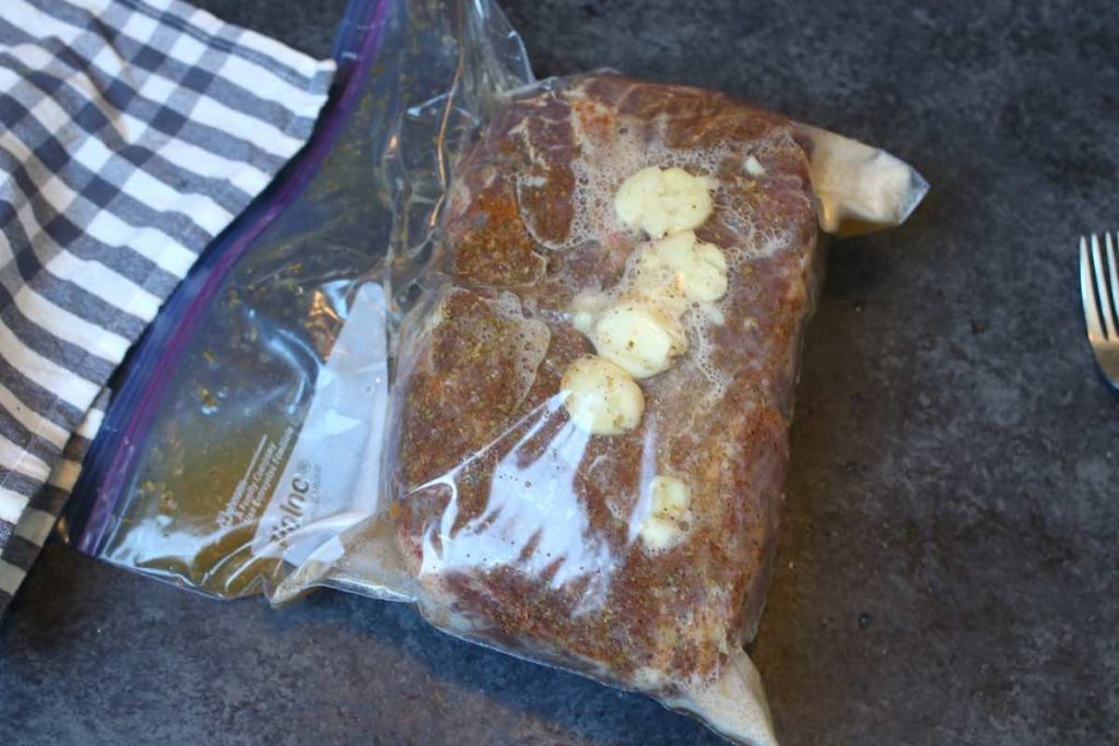 Vacuum-sealed pork shoulder in a ziplock bag.