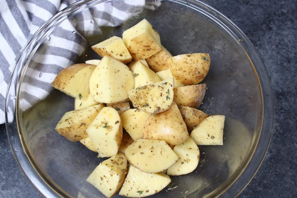 Season the cubed potatoes in a large bowl.
