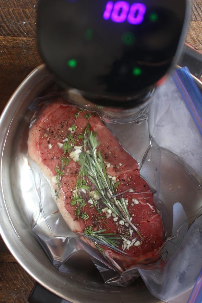 Cooking vacuum-sealed steak in a sous vide water bath.