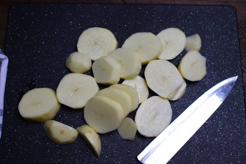 Slicing potatoes into evenly-sized pieces.