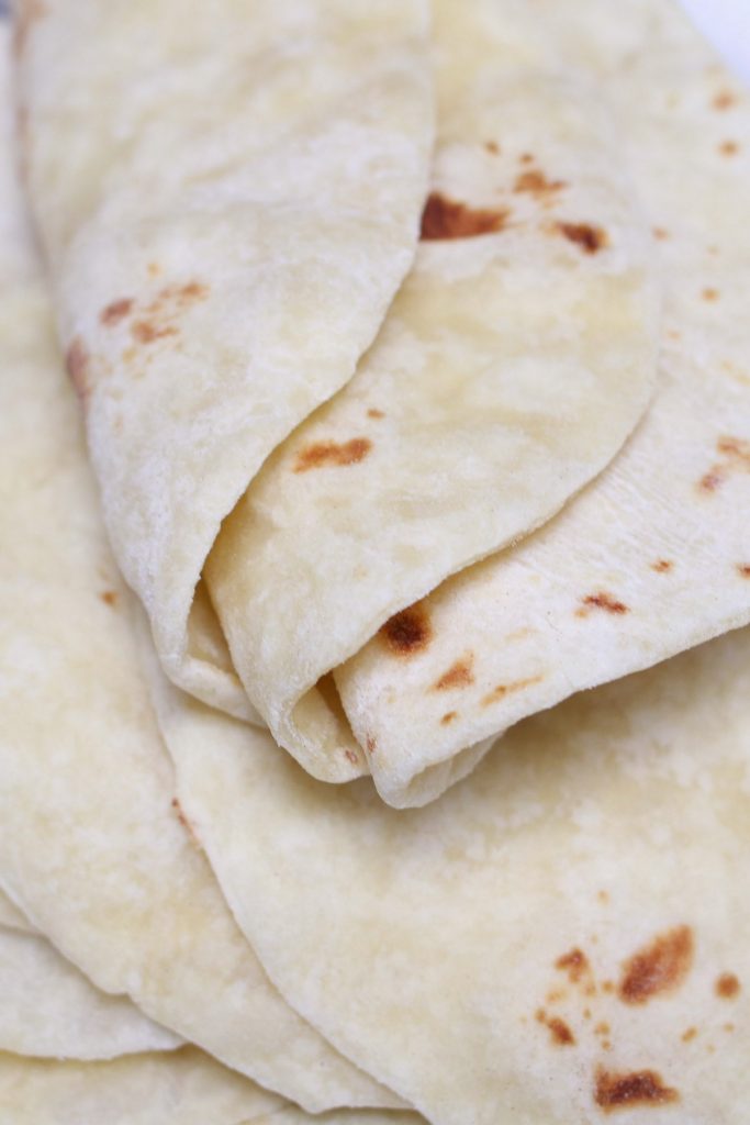 These Homemade Vegan Flour Tortillas are so soft and fluffy – a delicious and healthy alternative to traditional Mexican tortillas. This recipe is easy to make with only 5 inexpensive, easy-to-get ingredients, and can be done completely by hand!