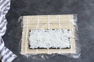 Spreading rice on top of the nori sheet.