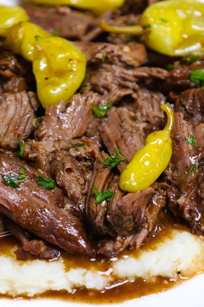 Ultimate Crockpot Mississippi Roast is amazingly juicy and fork-tender! It takes 10 minutes of prep in the morning and the roast is simmered in a rich and divine sauce all day in the slow cooker. Add some vegetables to the crockpot and you’ll have a perfect weeknight meal with build-in gravy. #MississippiRoast #MississippiPotRoast #SlowCookerMississippiPotRoast #CrockpotMississippiRoast