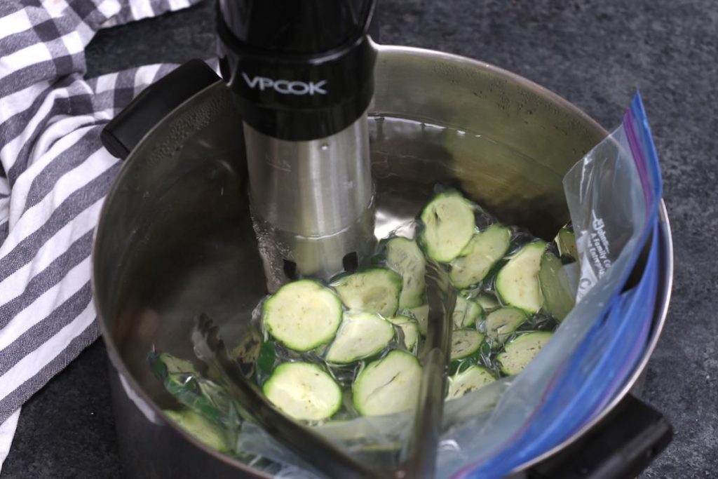 Cooking zucchini slices in a sous vide water bath.
