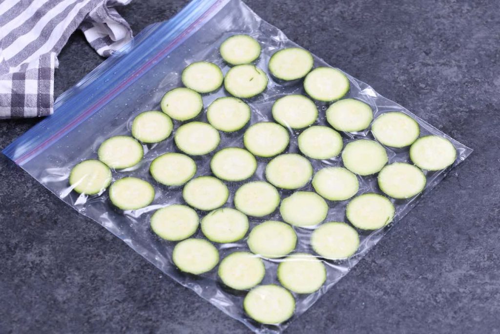 Arranging the zucchini slices in one single layer and than vacuum seal the bag. 