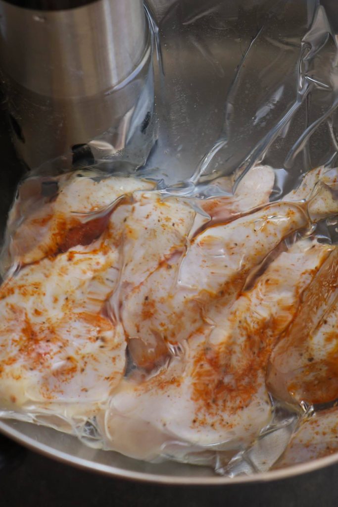 Sous vide cook chicken thighs in a warm water bath.