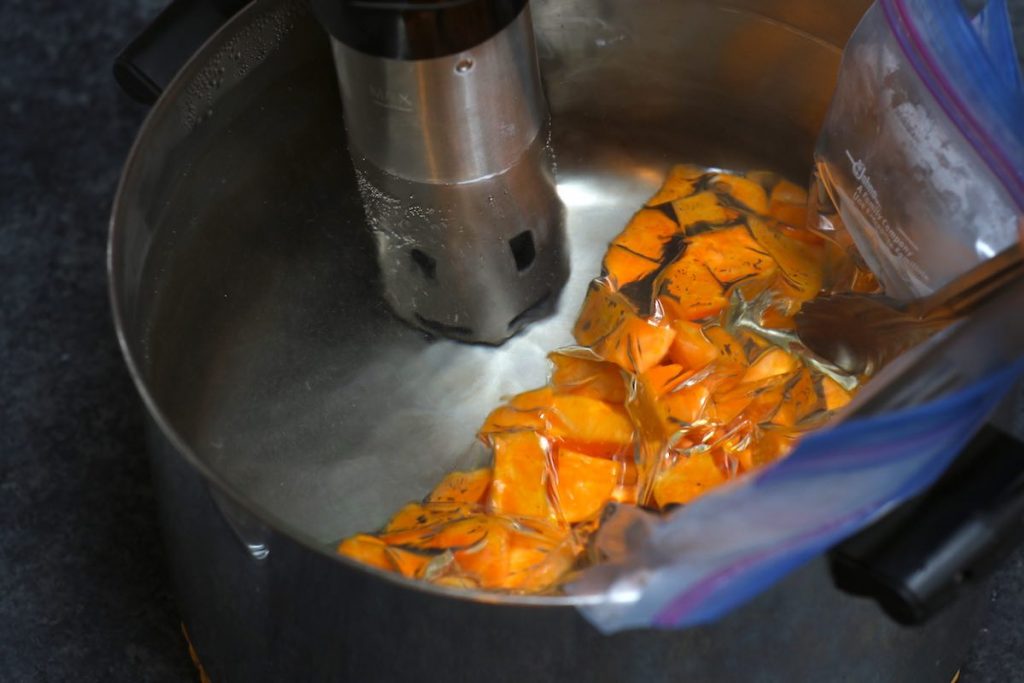 Sous vide cooking sweet potatoes in the warm water bath.