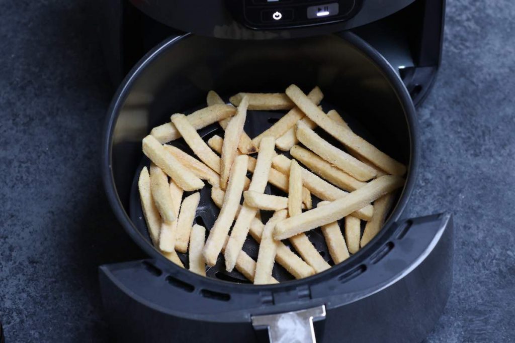 Spread frozen fries in the air fryer basket evenly.