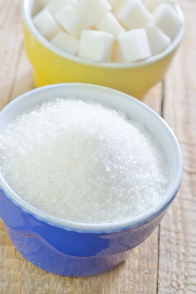 Granulated sugar in a blue bowl on the counter.