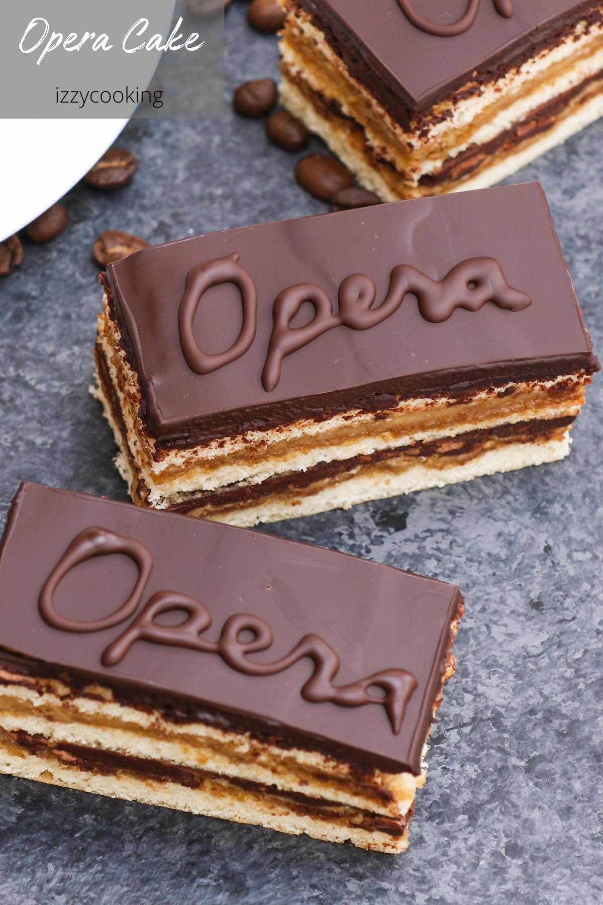 Opera Cake is a classic French dessert combining layers of almond sponge cake soaked in coffee syrup, espresso-flavored buttercream, and decadent chocolate ganache. It’s finished with a smooth chocolate glaze. This recipe has been tested many times and is easily the best homemade opera cake recipe that I’ve ever tried. #OperaCake #OperaCakeRecipe