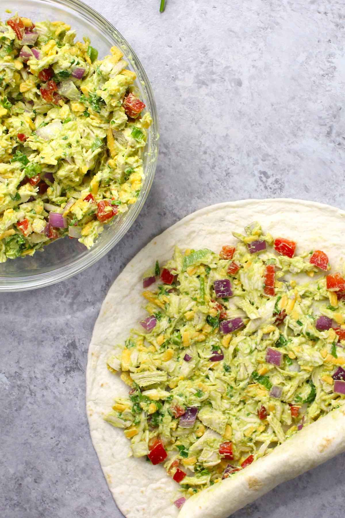 Photo showing rolling up chicken salad in a flour tortilla.