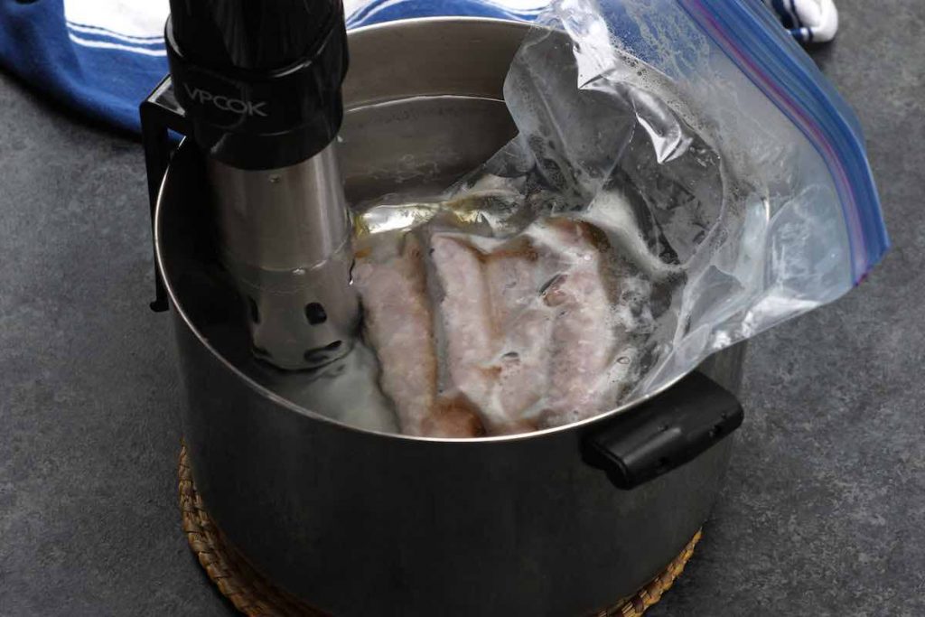 Cooking the vacuum sealed sausages in a sous vide water bath.