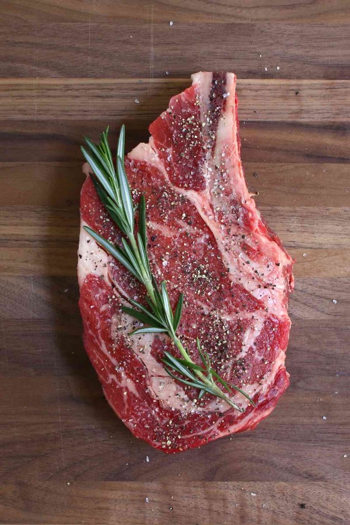 Seasoning the steak generously with salt and pepper before sous vide cooking.