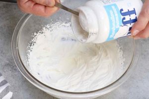 Adding marshmallow fluff to the whipped cream.