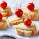 This Queso Manchego Crostini is an easy and delicious appetizer made with simple ingredients that pack in some big flavors! All you need is sliced bread, olive oil, Spanish Queso Manchego, and other favorite toppings to make a party platter or delightful finger food. #QuesoManchego #ManchegoCheese #Crostini