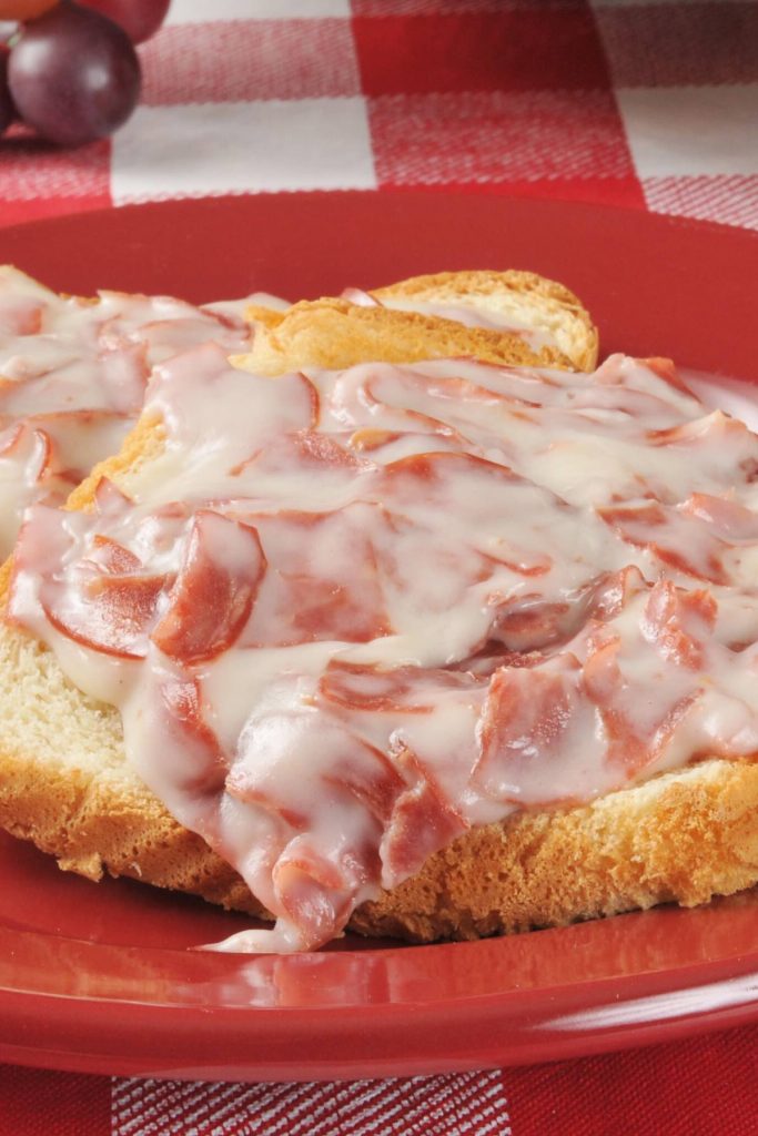 Shit On A Shingle is the ultimate comfort meal that’s fast and inexpensive. My mom used to make this for a quick breakfast, lunch or light dinner. Also called SOS, it’s a classic American military dish made with creamed chipped beef, and served over toast. This is a healthier version with lighter creamy white sauce. #ShitOnAShingle #ChippedBeef #CreamedChippedBeef