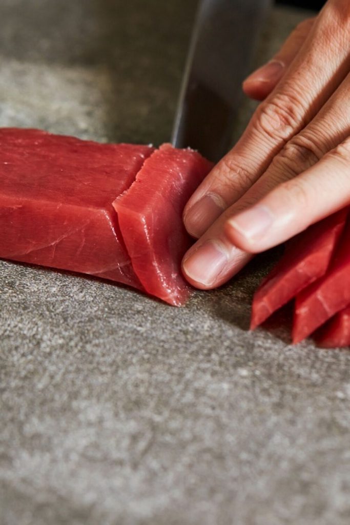 Slicing tuna into thin strips.
