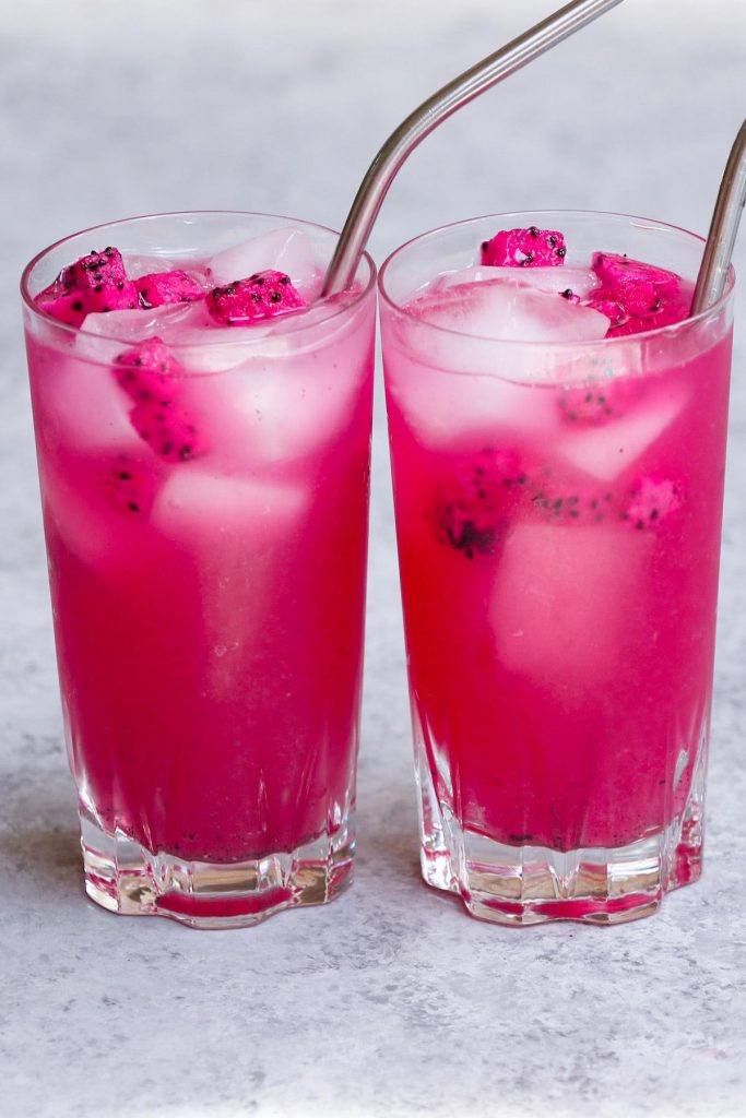 The beautiful pink Mango Dragonfruit Lemonade is a perfect summer refreshing drink that you can enjoy year-round. This easy Starbucks copycat recipe takes less than 5 minutes to make with only 4 ingredients. The dragon fruit powder gives this refresher a vibrant pink color, while the lemonade adds extra tropical fruity flavors to the iced beverage! #MangoDragonfruitLemonadeRefresher #StarbucksMangoDragonLemonade #StarbucksPinkLemonade