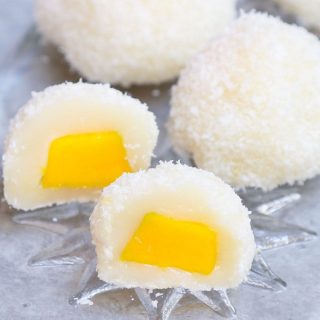 Mango Mochi has tangy and sweet mango filling on the inside, soft and chewy mochi cake on the outside. It’s rolled into mango mochi balls with a delicious shredded coconut coating, perfect for a hot summer day! This recipe is quick to make, and can be easily customized for vegan or dairy-free preferences.