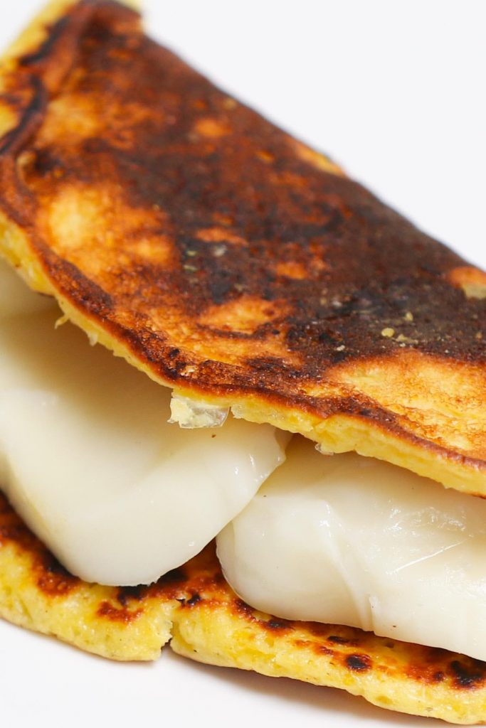 Cachapas are soft, sweet, and savory corn pancakes – a delicious Venezuelan breakfast dish. Made with fresh corn and a few other simple ingredients, these cachapas can be easily folded over a cheese filling such as Queso de Mano, mozzarella, or cream cheese. Incredibly delicious! (No special flour needed.) #cachapas