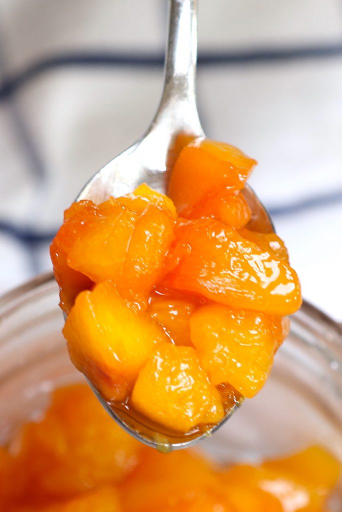 Closeup of a spoonful of peach compote.
