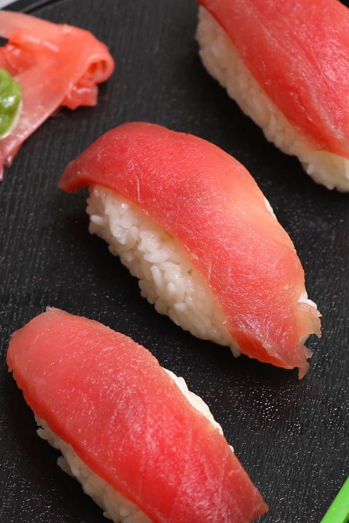 Tuna Nigiri is made with sashimi-grade tuna and vinegared sushi rice – so much easier to make than maki sushi rolls! We’ll show you some simple techniques and tips so that you can make this delicious tuna sushi at home. Plus you’ll find how to cut raw tuna and customize this recipe by using cooked tuna or other seafood, or alternatives like vegetables. #TunaNigiri