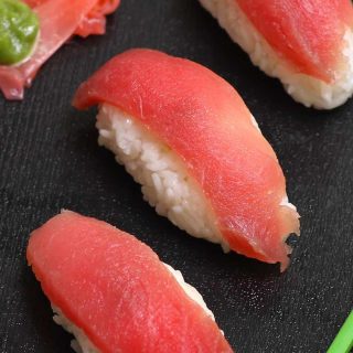 Tuna Nigiri is made with sashimi-grade tuna and vinegared sushi rice – so much easier to make than maki sushi rolls! We’ll show you some simple techniques and tips so that you can make this delicious tuna sushi at home. Plus you’ll find how to cut raw tuna and customize this recipe by using cooked tuna or other seafood, or alternatives like vegetables. #TunaNigiri