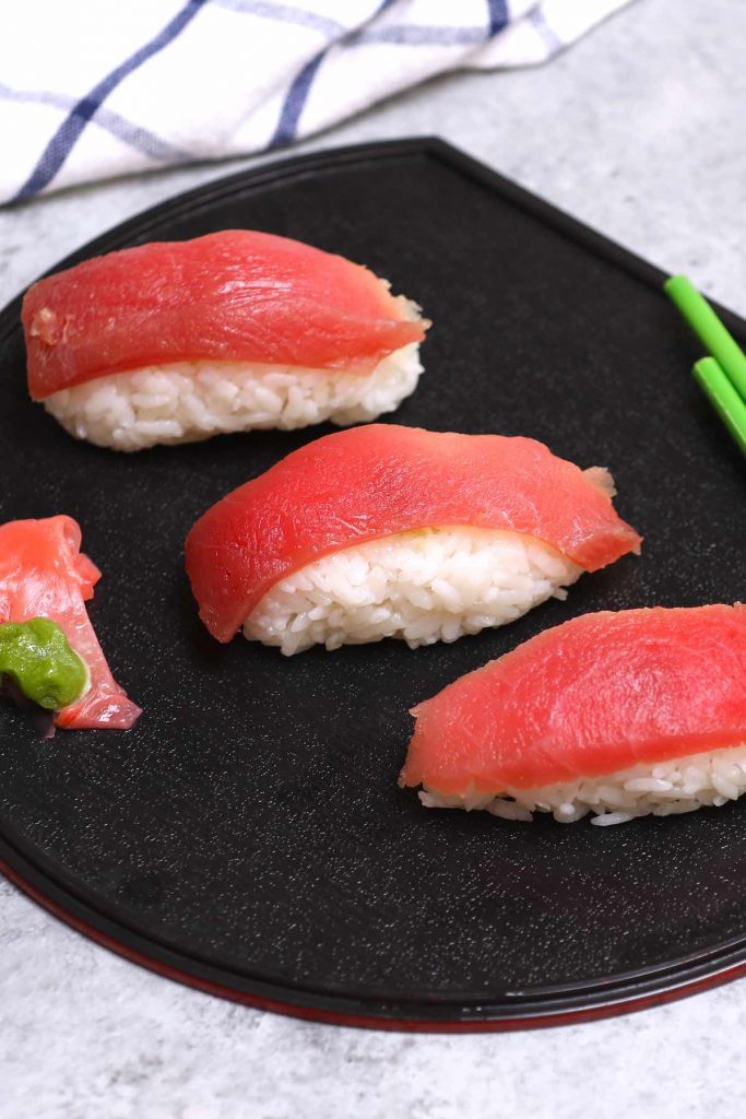 Tuna Nigiri is made with sashimi-grade tuna and vinegared  sushi rice – so much easier to make than maki sushi rolls! We’ll show you some simple techniques and tips so that you can make this delicious tuna sushi at home. Plus you’ll find how to cut raw tuna and customize this recipe by using cooked tuna or other seafood, or alternatives like vegetables. #TunaNigiri 