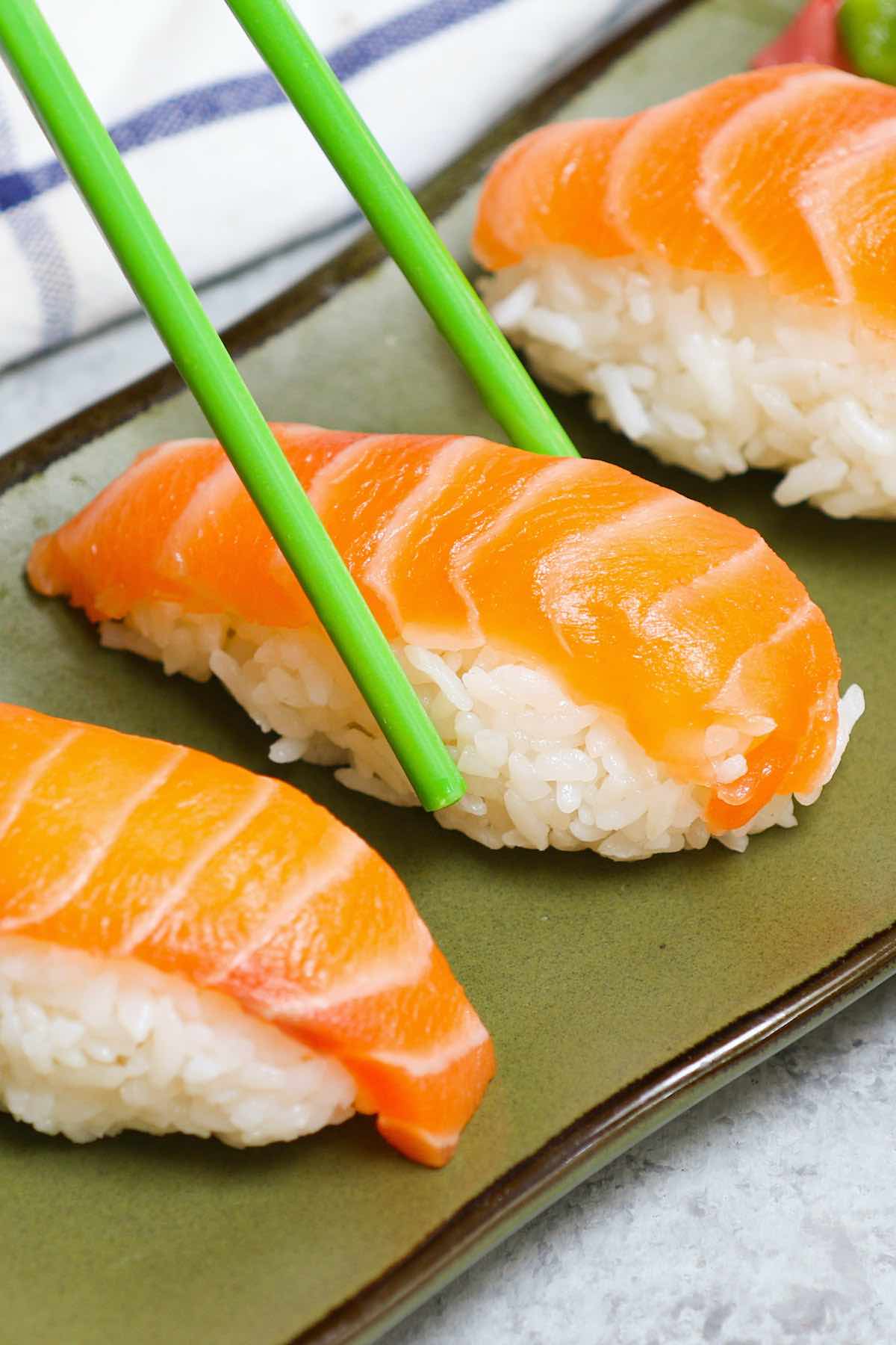Salmon Nigiri made with sashimi-grade salmon and fluffy sushi rice! It’s so much cheaper than the restaurant, and incredibly easy to make at home. I’ll share with you the secrets to cut salmon for nigiri or sashimi and how to make salmon nigiri sushi with step by step photos.