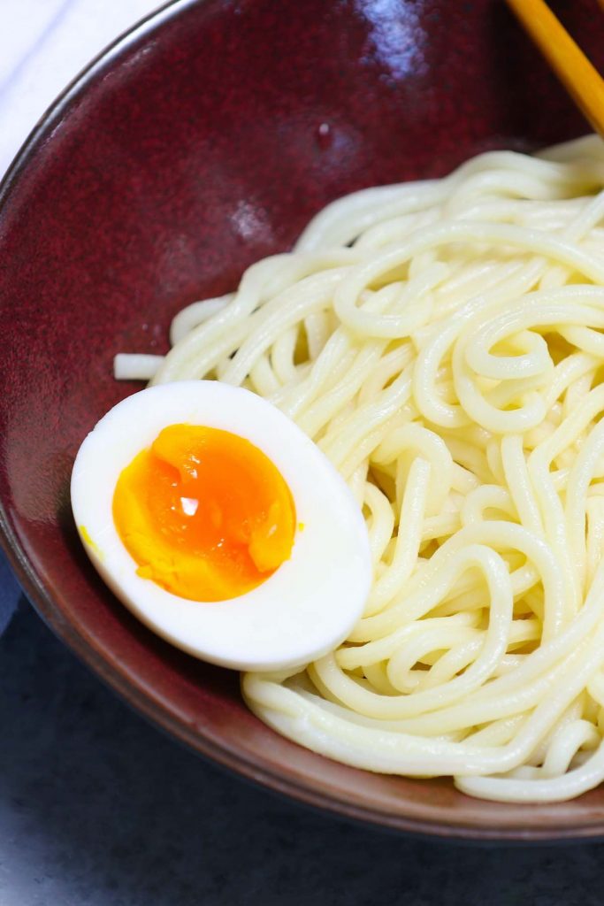 Soft-boiled eggs served on top of ramen noodles.