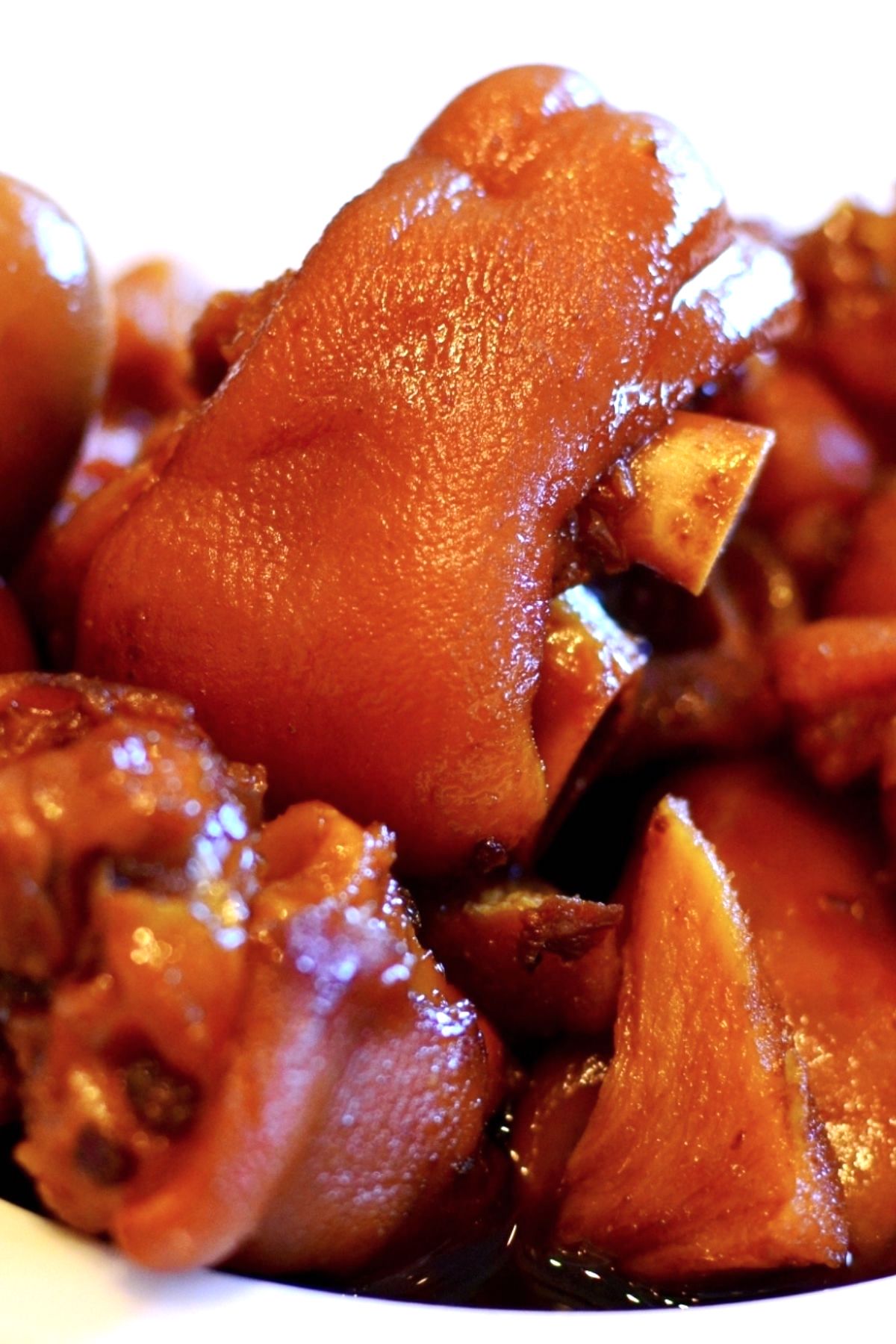 Braised Pig’s Feet are tender, juicy, and flavorful – cooked long and slow in a rich sauce. Pig feet or pig trotters are considered one of the most delicious parts of pork. My family makes this recipe for regular weekdays and special occasions like Chinese New Year. Serve them with mashed potatoes and green vegetables for an amazing meal! #PigFeet #PigFeetRecipe #PigTrotters #PorkFeet