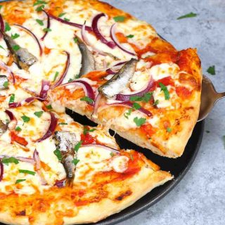 Sardine Pizza is my go-to meal when I have canned sardines and onions on hand. This classic Italian recipe is really easy and delicious. You’ll want to make this homemade pizza over and over again! #SardinePizza